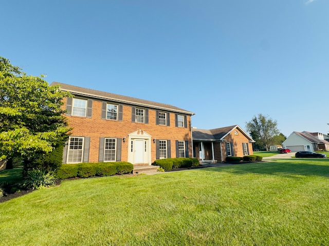 colonial-style house with brick siding and a front yard