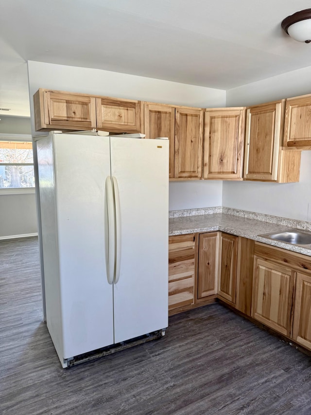 kitchen with a sink, dark wood-style floors, light countertops, and freestanding refrigerator