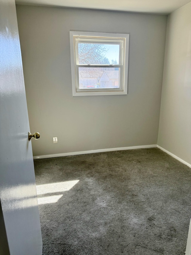 unfurnished room featuring carpet flooring and baseboards