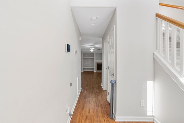 corridor with baseboards and light wood-style flooring