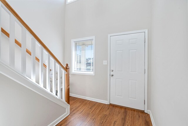 entrance foyer with stairway, wood finished floors, and baseboards