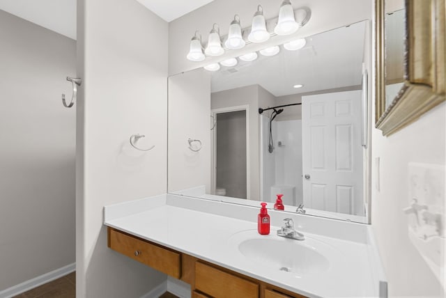 bathroom featuring tile patterned floors, vanity, a shower, and baseboards