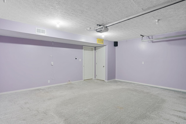 garage with visible vents, baseboards, and a garage door opener