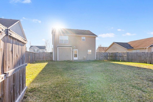 back of house featuring a lawn and a fenced backyard