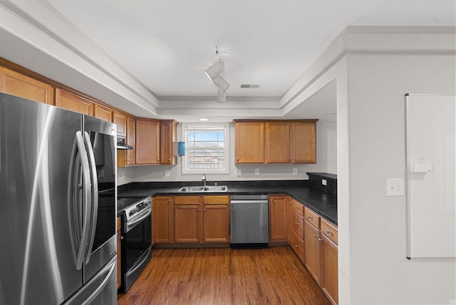 kitchen featuring a sink, stainless steel appliances, dark countertops, and visible vents