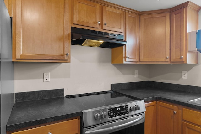 kitchen featuring under cabinet range hood, dark countertops, stainless steel electric range, and brown cabinetry