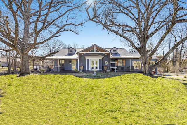 view of front of house with french doors, covered porch, metal roof, and a front lawn