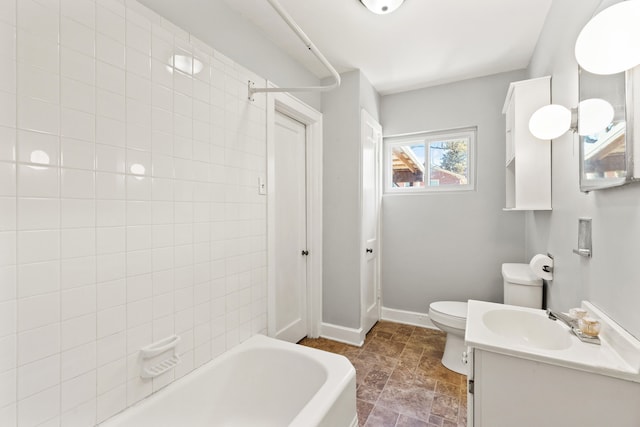 bathroom with vanity, baseboards, stone finish flooring, shower / washtub combination, and toilet