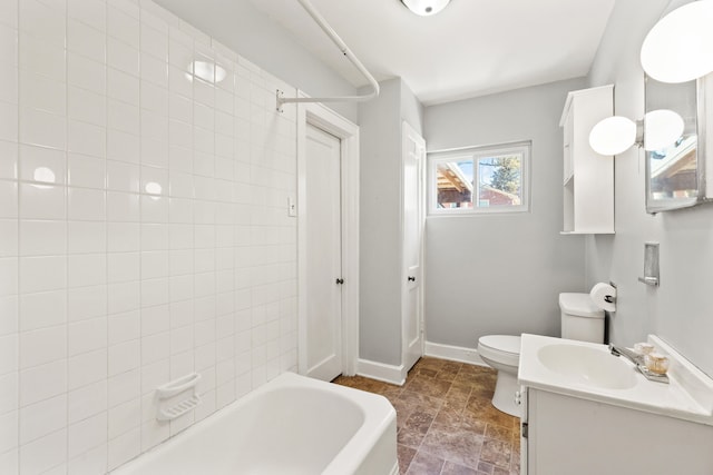 bathroom with baseboards, toilet, vanity, bathing tub / shower combination, and stone finish flooring