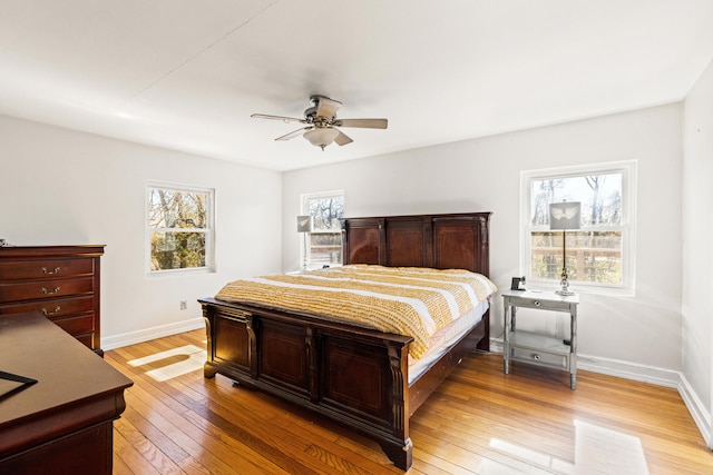 bedroom featuring a ceiling fan, light wood-style floors, and baseboards