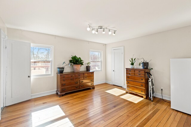bedroom featuring light wood finished floors and baseboards