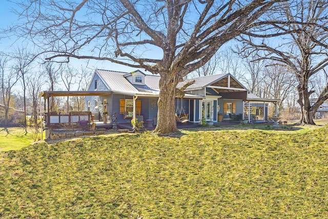 view of front of property featuring metal roof, a porch, and a front yard