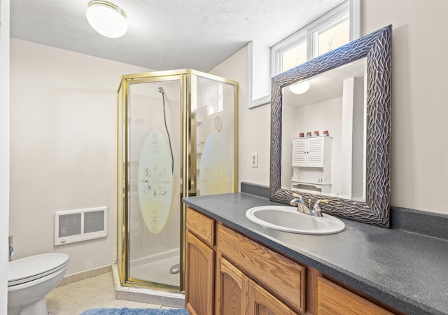 bathroom featuring tile patterned flooring, vanity, a stall shower, and a textured ceiling