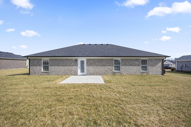 back of house with a yard, a patio area, brick siding, and a shingled roof