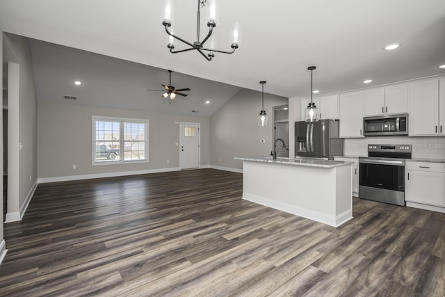 kitchen featuring tasteful backsplash, dark wood-type flooring, open floor plan, vaulted ceiling, and stainless steel appliances