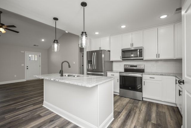 kitchen with dark wood-type flooring, a kitchen island with sink, a sink, appliances with stainless steel finishes, and white cabinets