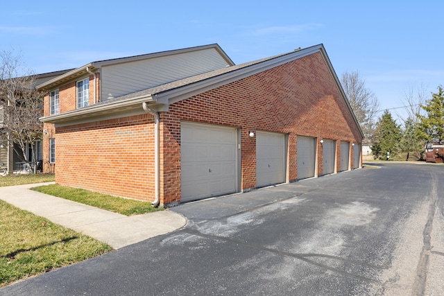 view of side of property with community garages and brick siding