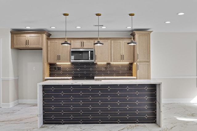 kitchen featuring stainless steel microwave, recessed lighting, marble finish floor, and baseboards