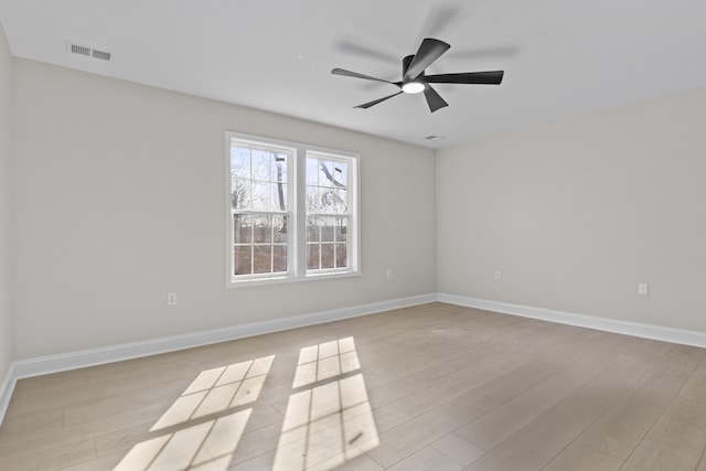 spare room with visible vents, baseboards, light wood-style floors, and ceiling fan