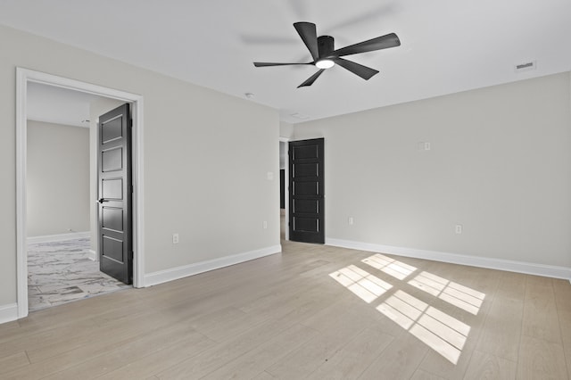 unfurnished room featuring visible vents, a ceiling fan, light wood-style floors, and baseboards