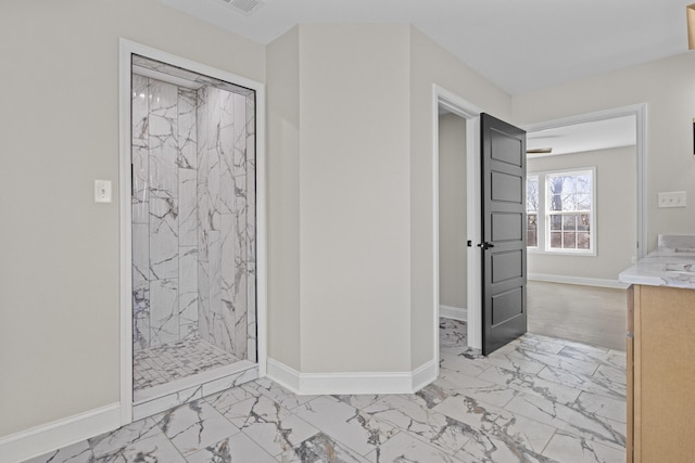 bathroom featuring a marble finish shower, marble finish floor, and baseboards