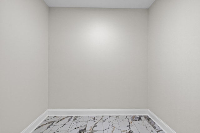 empty room featuring baseboards and marble finish floor