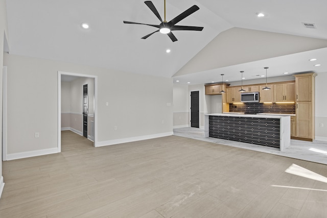 unfurnished living room with light wood-style floors, a ceiling fan, visible vents, and high vaulted ceiling