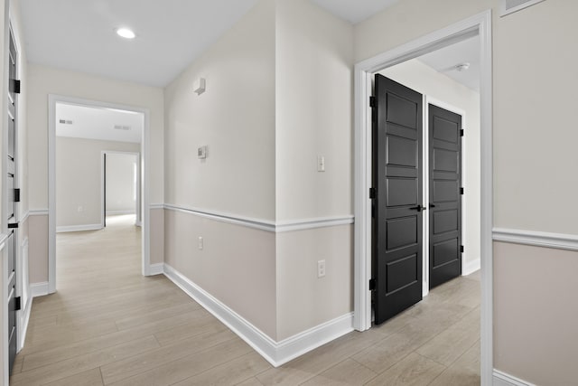 hallway with light wood-style flooring, recessed lighting, and baseboards