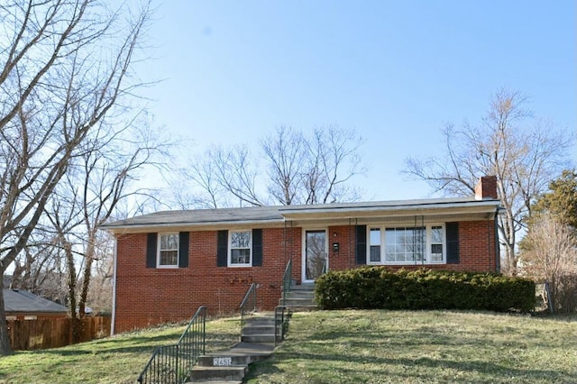 single story home featuring brick siding, a chimney, a front lawn, and fence