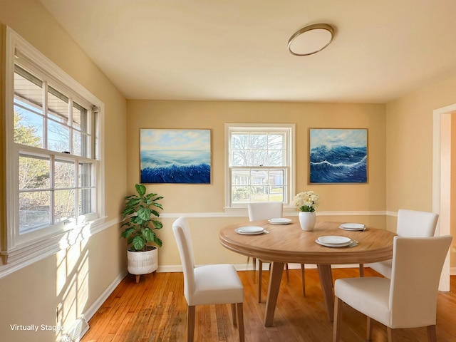 dining space featuring light wood-style flooring and baseboards