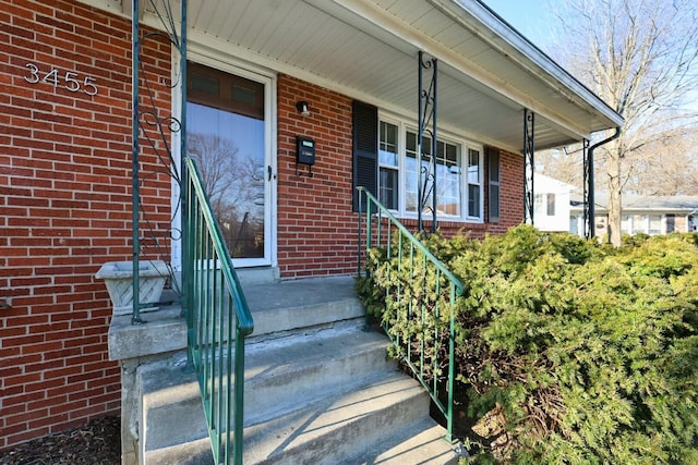 entrance to property with brick siding and covered porch