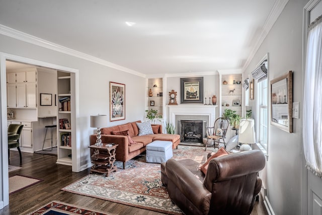 living room with dark wood-type flooring, baseboards, built in features, ornamental molding, and a fireplace