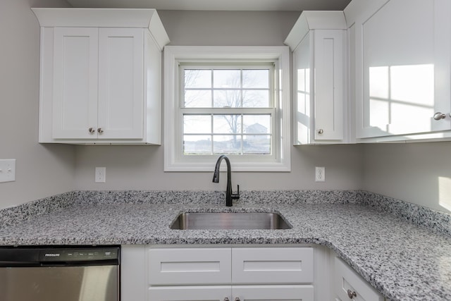 kitchen with white cabinets, dishwasher, light stone countertops, and a sink