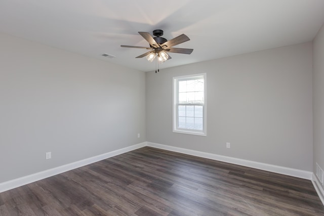 unfurnished room featuring visible vents, baseboards, and dark wood-style floors