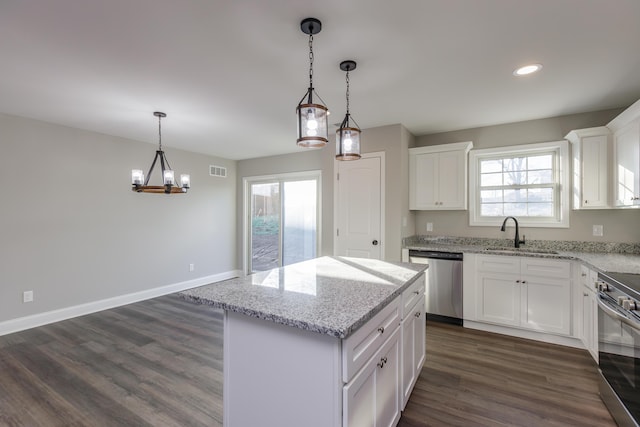 kitchen featuring baseboards, dark wood finished floors, white cabinets, stainless steel appliances, and a sink