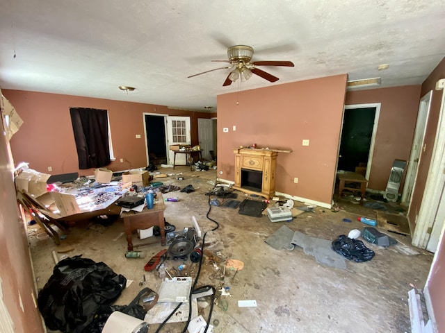 living area with a textured ceiling and ceiling fan