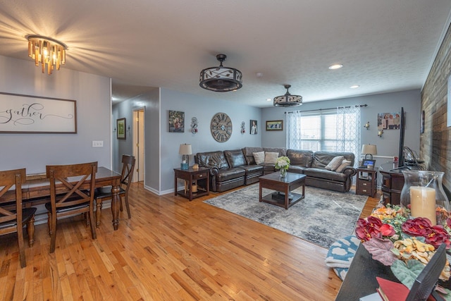 living room featuring recessed lighting, a textured ceiling, light wood-type flooring, and a wood stove