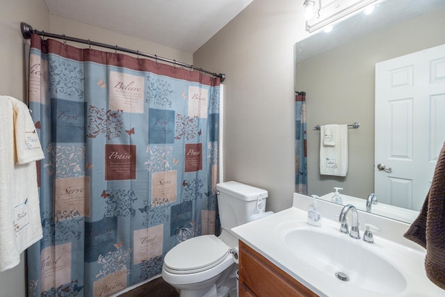 full bathroom with toilet, vanity, and a textured ceiling