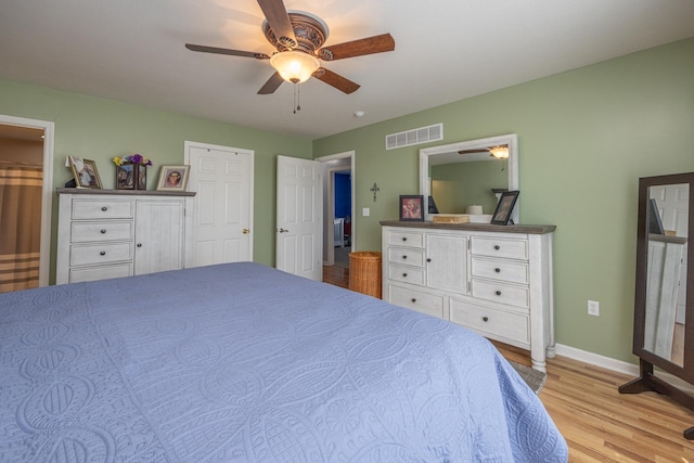 bedroom with visible vents, light wood-style flooring, a ceiling fan, and baseboards