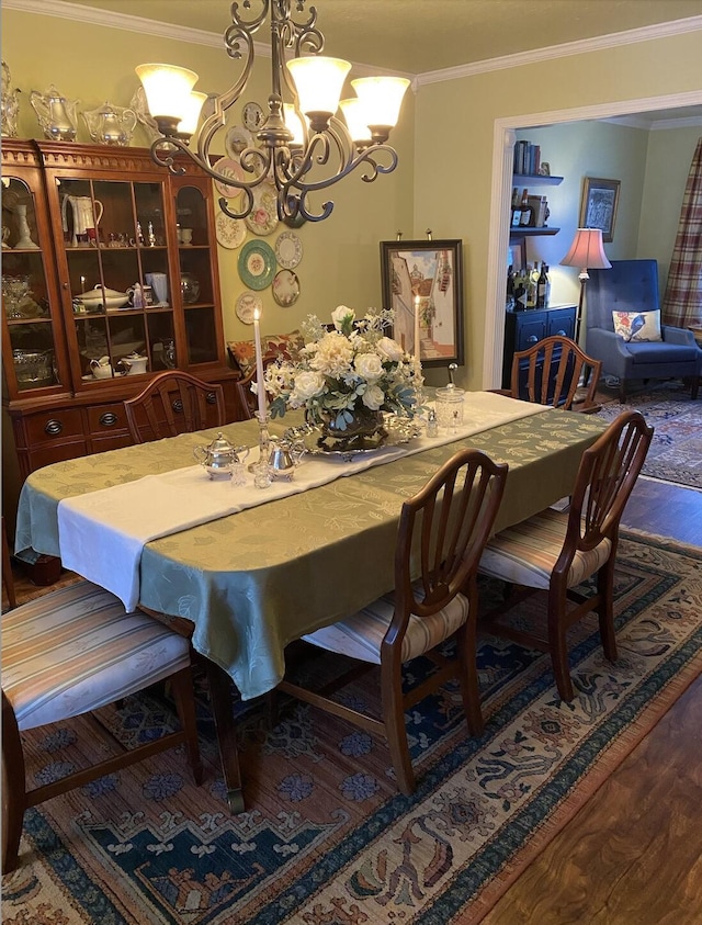 dining space with a notable chandelier, wood finished floors, and crown molding