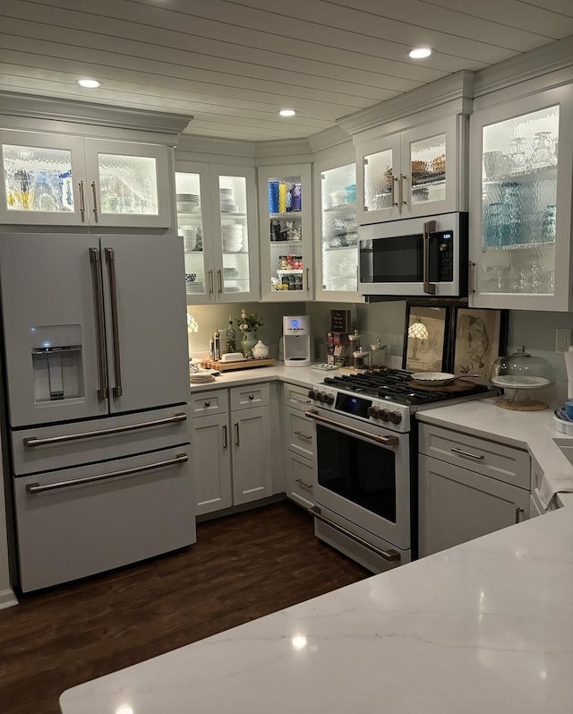 kitchen featuring light countertops, glass insert cabinets, dark wood-type flooring, and stainless steel appliances