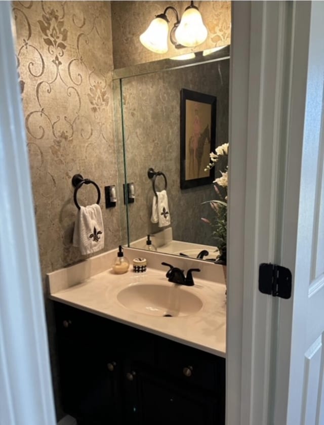 bathroom with wallpapered walls and vanity