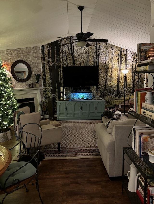 living room with dark wood-style floors, ceiling fan, an outdoor fireplace, and vaulted ceiling