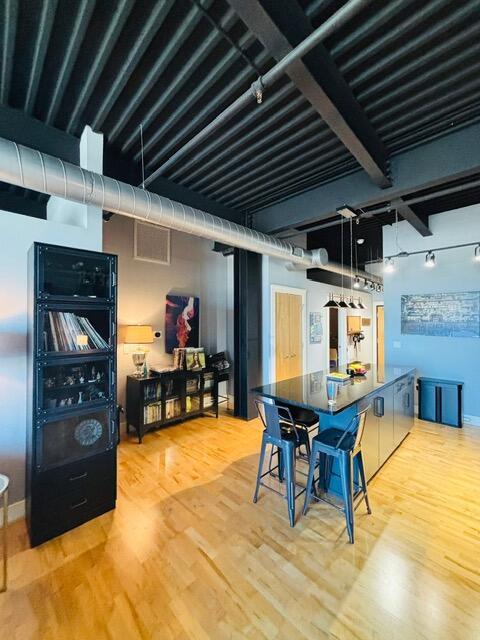 kitchen with dark countertops, track lighting, light wood-style flooring, and baseboards