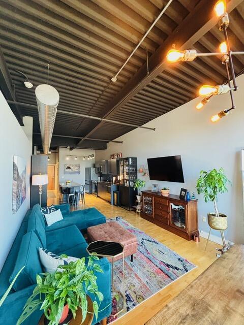 living room featuring beam ceiling and wood finished floors