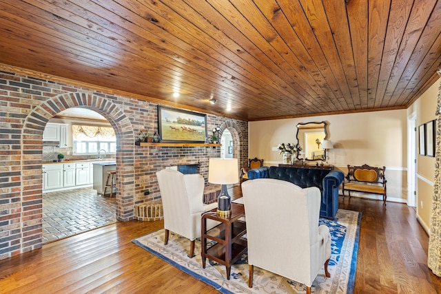 living room featuring wood ceiling, wood finished floors, arched walkways, and brick wall