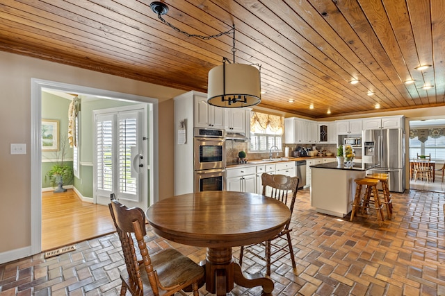 dining room with baseboards, visible vents, recessed lighting, brick floor, and wooden ceiling