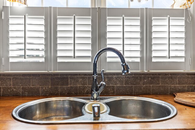 room details featuring decorative backsplash, dark countertops, and a sink