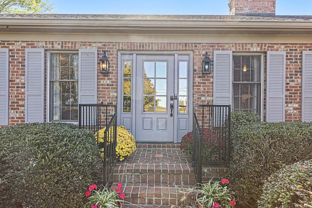 view of exterior entry featuring brick siding