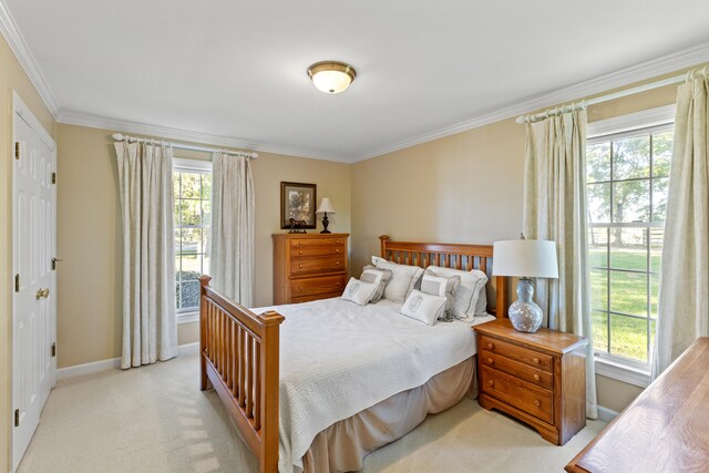 bedroom with baseboards, multiple windows, light colored carpet, and ornamental molding